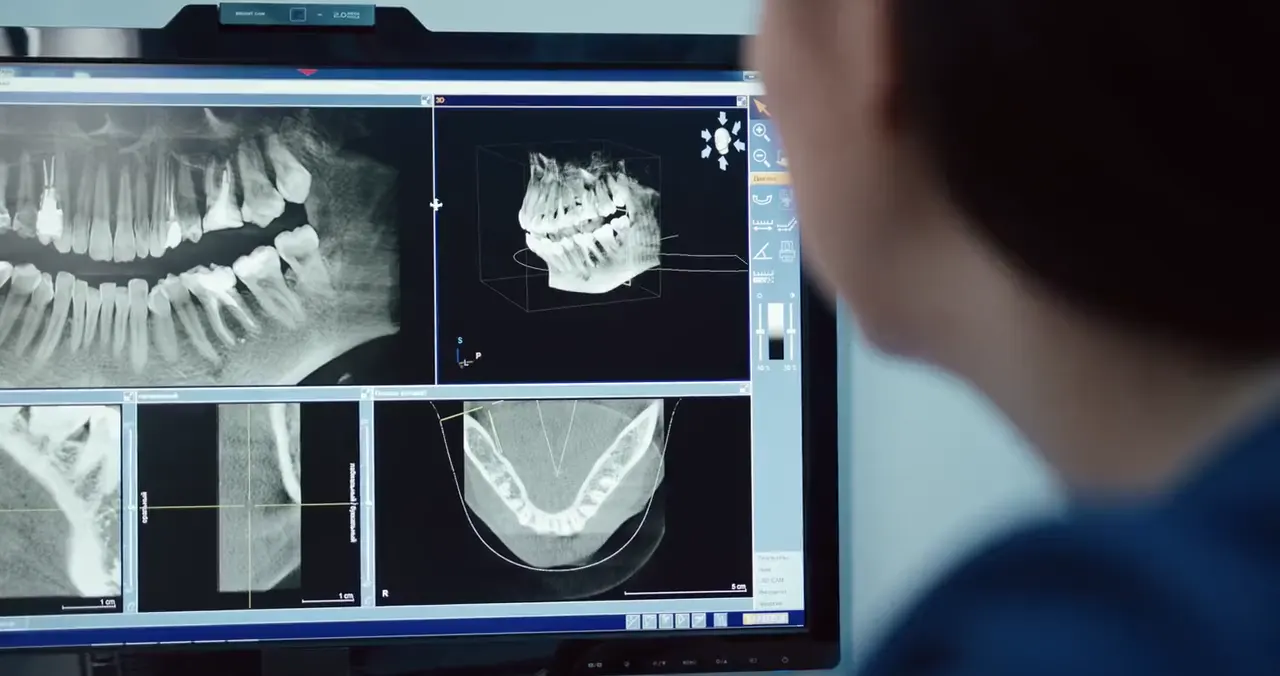 Una dentista mira a la pantalla les imatges en 3D d'una boca